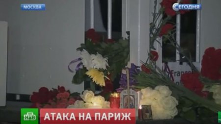 Люди несут цветы и свечи к посольству Франции в Москве 