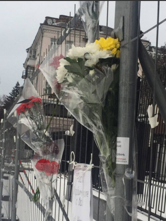 Украинцы несут цветы и свечи к зданию посольства России в Киеве